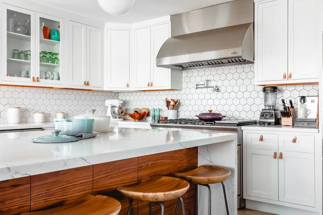 A clean kitchen with bright cabinetry and polished worktops